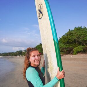 girl on the beach with a surfboard